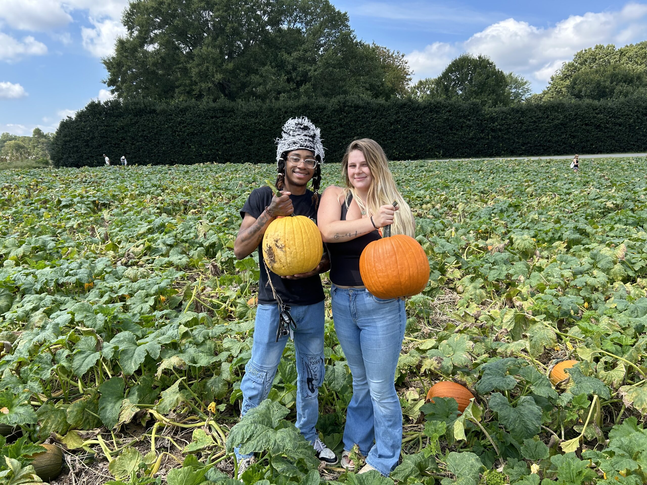 Two pumpkin pickers hold their pumpkins while standing in the 20 acre pumpkin patch at Carrigan Farms in Mooresville, NC.